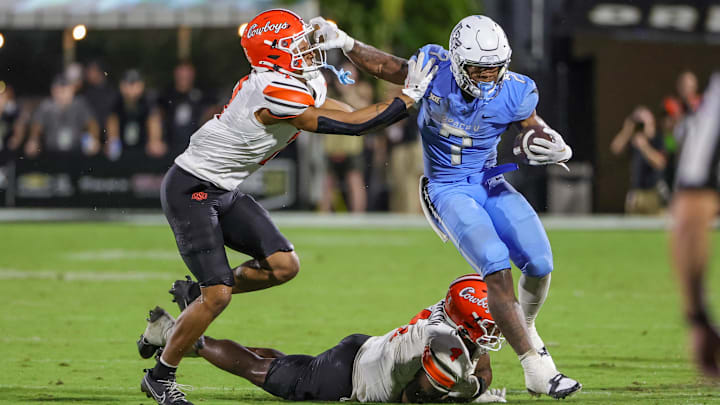 Nov 11, 2023; Orlando, Florida, USA; UCF Knights running back RJ Harvey (7) is pushed out of bounds by Oklahoma State Cowboys safety Cameron Epps (7) during the second half at FBC Mortgage Stadium. Mandatory Credit: Mike Watters-USA TODAY Sports