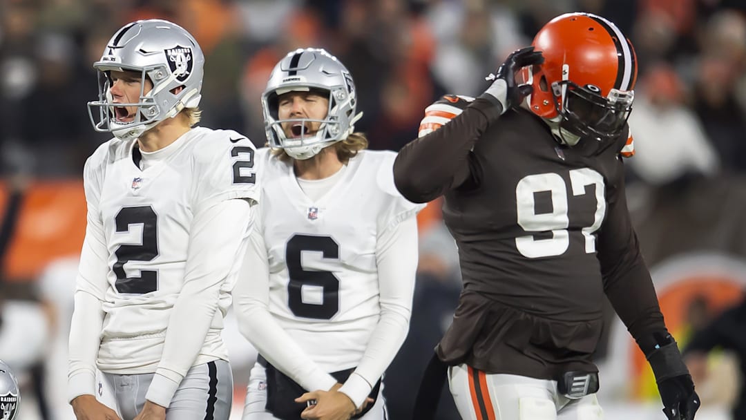 Dec 20, 2021; Cleveland, Ohio, USA; Las Vegas Raiders kicker Daniel Carlson (2) and holder A.J. Cole (6) celebrate after Carlson kicked the game-winning field goal as Cleveland Browns defensive tackle Malik Jackson (97) walks off the field during the fourth quarter at FirstEnergy Stadium.