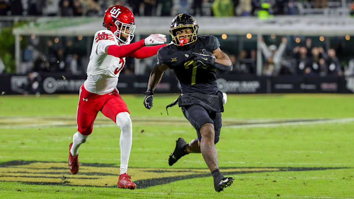 Nov 29, 2024; Orlando, Florida, USA; UCF Knights running back RJ Harvey (7) carries the ball as Utah Utes cornerback Smith Snowden (2) moves in during the second quarter at FBC Mortgage Stadium. Mandatory Credit: Mike Watters-Imagn Images Nov 29, 2024; Orlando, Florida, USA; UCF Knights running back RJ Harvey (7) carries the ball as Utah Utes cornerback Smith Snowden (2) moves in during the second quarter at FBC Mortgage Stadium. Mandatory Credit: Mike Watters-Imagn Images