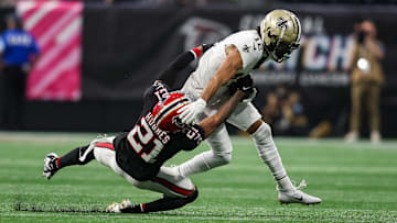 Sep 29, 2024; Atlanta, Georgia, USA; New Orleans Saints wide receiver Chris Olave (12) is tackled by Atlanta Falcons cornerback Mike Hughes (21) in the first quarter at Mercedes-Benz Stadium. Mandatory Credit: Brett Davis-Imagn Images