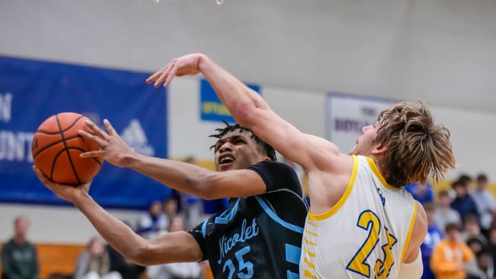 Nicolet's Davion Hannah (25) is fouled under the hoop by Catholic Memorial's Bennett McCormick (23) during the game in Waukesha, Tuesday, Jan. 17, 2023.

Wcn Ns Bball 2083