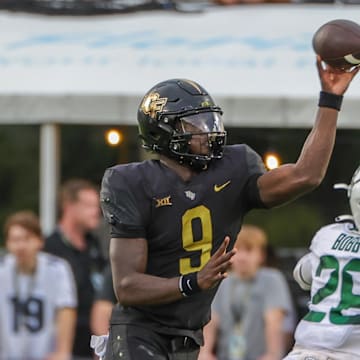 Sep 30, 2023; Orlando, Florida, USA; UCF Knights quarterback Timmy McClain (9) throws a pass in front of Baylor Bears safety Devyn Bobby (28) during the second half at FBC Mortgage Stadium. Mandatory Credit: Mike Watters-Imagn Images