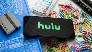 In this photo illustration a Hulu logo seen displayed on a...