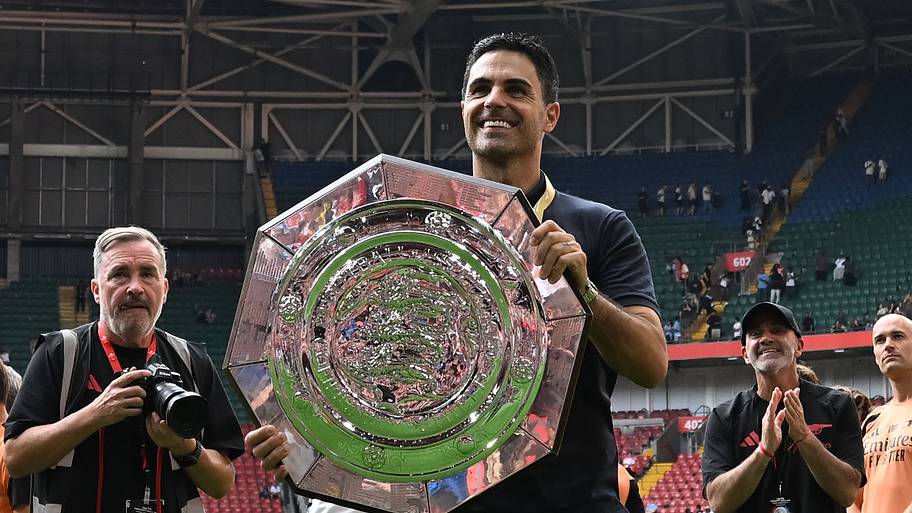 Mikel Arteta with his hands on the big plate.