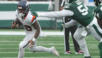 East Rutherford, NJ -- September 29 -- Tyler Badie of Denver runs from Javon Kinlaw of the Jets in the first half as the Denver Broncos edged the New York Jets 10-9 at MetLife Stadium.