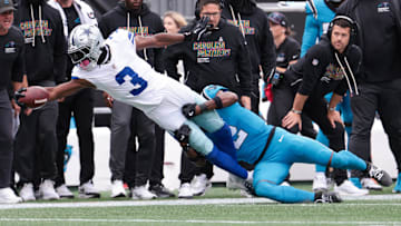 Oct 12, 2025; Charlotte, North Carolina, USA;  Dallas Cowboys wide receiver George Pickens (3) reaches while Carolina Panthers cornerback Mike Jackson (2) tackles during the second half at Bank of America Stadium.