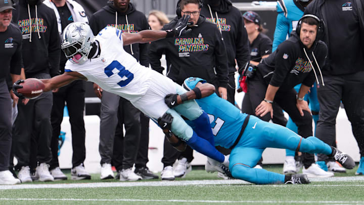 Oct 12, 2025; Charlotte, North Carolina, USA;  Dallas Cowboys wide receiver George Pickens (3) reaches while Carolina Panthers cornerback Mike Jackson (2) tackles during the second half at Bank of America Stadium.