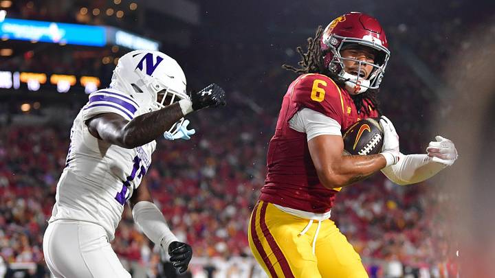 Nov 7, 2025; Los Angeles, California, USA; Southern California Trojans wide receiver Makai Lemon (6) scores a touchdown against Northwestern Wildcats defensive back Josh Fussell (13) during the first half at the Los Angeles Memorial Coliseum. Mandatory Credit: Gary A. Vasquez-Imagn Images