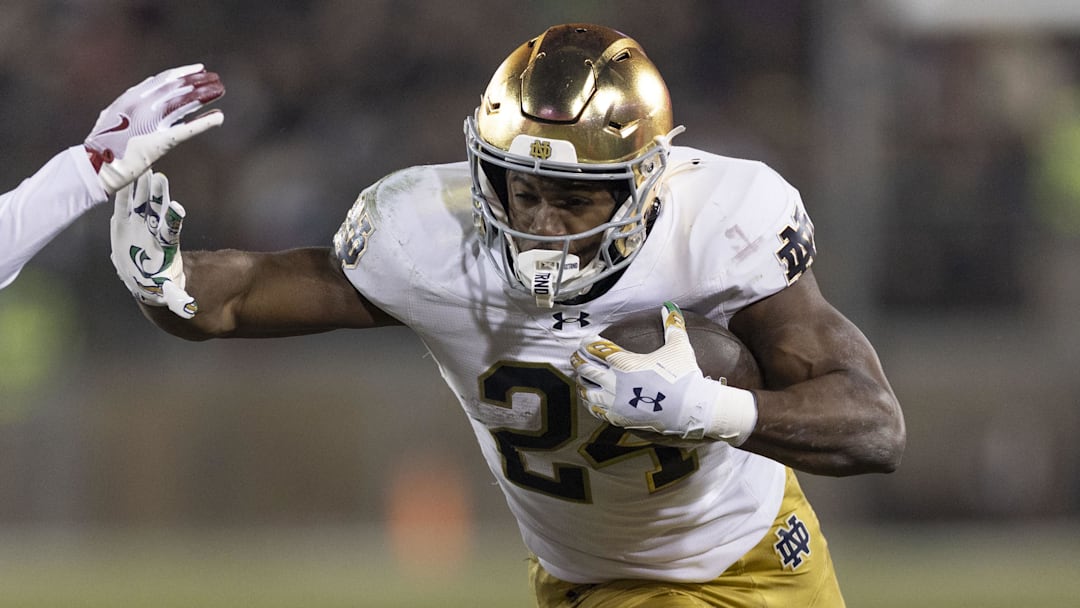 Nov 29, 2025; Stanford, California, USA;  Notre Dame Fighting Irish running back Jadarian Price (24) runs with the football against Stanford Cardinal safety Darrius Davis (29) during the first quarter at Stanford Stadium. 