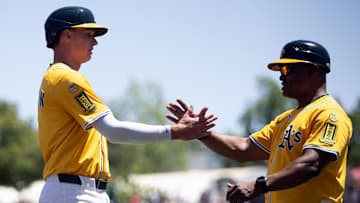 May 25, 2025; West Sacramento, California, USA; Athletics first baseman Logan Davidson (6) gets a congratulatory handshake from third base coach Eric Martins after getting his first hit and RBI against the Philadelphia Phillies during the first inning at Sutter Health Park. Mandatory Credit: D. Ross Cameron-Imagn Images