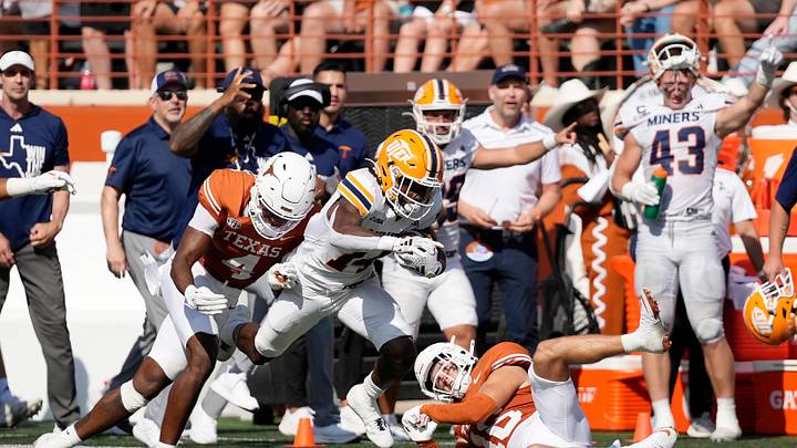 Sep 13, 2025; Austin, Texas, USA; Texas El Paso Miners running back Hahsaun Wilson (14) runs for yards while defended by Texas Longhorns defensive backs Jelani McDonald (4) and Michael Taaffe (16) during the first half Darrell K Royal-Texas Memorial Stadium. Mandatory Credit: Scott Wachter-Imagn Images