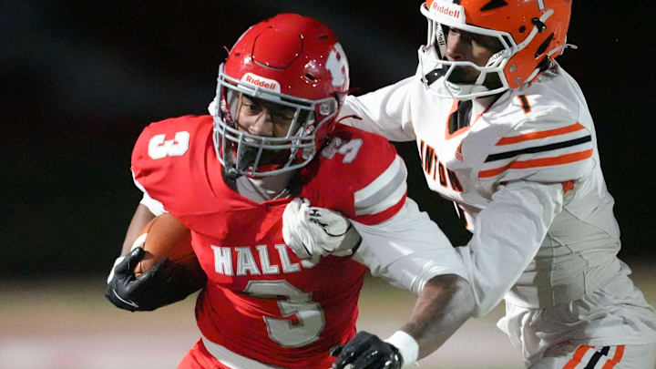 Halls' Jarrell Chandler (3) is grabbed by Clinton’s Braylen Hayden (1) in a TSSAA high school football game on October 31, 2025, in Knoxville, Tenn.