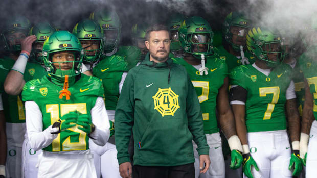 Oregon head coach Dan Lanning, center, waits to take the field with his team for their game against Oregon State at Autzen St