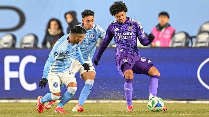 Mar 8, 2025; New York, New York, USA; Orlando City forward Gustavo Caraballo (65) controls the ball defended by New York City FC forward Agustín Ojeda (26) and midfielder Maximiliano Moralez (10) during the second half at Yankee Stadium. Mandatory Credit: Mark Smith-Imagn Images