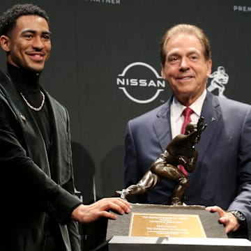 Heisman winner Alabama quarterback Bryce Young poses for pictures with head coach Nick Saban.