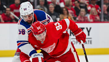 Apr 5, 2024; Detroit, Michigan, USA; Detroit Red Wings right wing Alex DeBrincat (93) brings the puck up ice as New York Rangers defenseman Ryan Lindgren (55) defends during the second period at Little Caesars Arena. Mandatory Credit: Tim Fuller-Imagn Images
