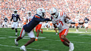 Nov 22, 2025; Auburn, Alabama, USA; Mercer Bears wide receiver Adjatay Dabbs (18) is pushed out of bounds by Auburn Tigers safety Kaleb Harris (8) during the first quarter at Jordan-Hare Stadium. Mandatory Credit: John Reed-Imagn Images