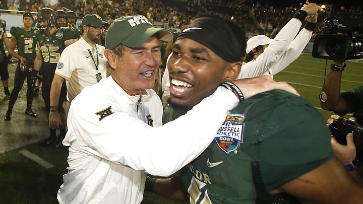 Dec 29, 2015; Orlando, FL, USA; Baylor Bears senior Jay Lee (4) gives Baylor Bears head coach Art Briles a hug  following a football game at Florida Citrus Bowl. Baylor won 49-38. Mandatory Credit: Reinhold Matay-Imagn Images