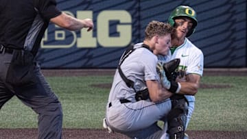Oregon’s Anson Aroz, right, collides with Utah Valley catcher Mason Strong at the plate in the eighth inning of the Eugene NCAA Regional at PK Park.