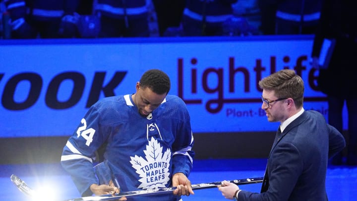 Mar 8, 2022; Toronto, Ontario, CAN; Toronto Maple Leafs general manager Kyle Dubas (right) presents forward Wayne Simmonds (24) with a silver stick after having played in his 1,000th game before a game against the Seattle Kraken at Scotiabank Arena. Mandatory Credit: John E. Sokolowski-USA TODAY Sports