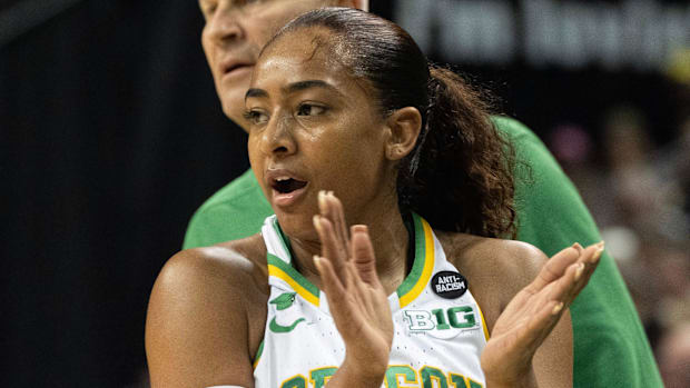 Oregon coach Kelly Graves and player Deja Kelly try to rally the team during the first half against Iowa at Matthew Knight Ar