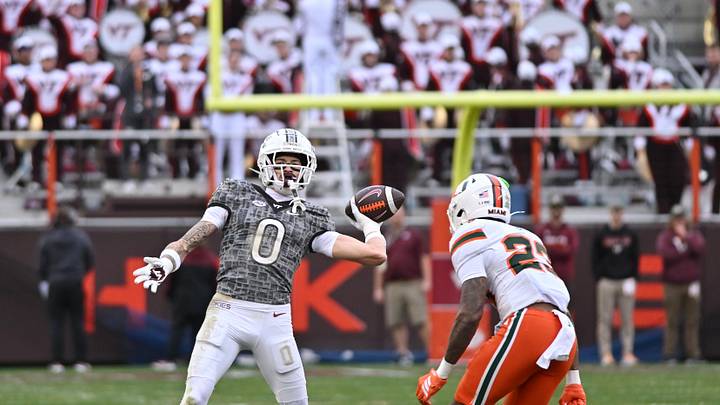 Nov 22, 2025; Blacksburg, Virginia, USA;  Virginia Tech Hokies wide receiver Ayden Greene (0) throws a pass as Miami (FL) Hurricanes defensive back Dylan Day (23) pursues during the fourth quarter at Lane Stadium. Mandatory Credit: Brian Bishop-Imagn Images
