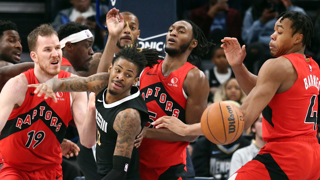 Jan 3, 2024; Memphis, Tennessee, USA; Memphis Grizzlies guard Ja Morant (12) looses control of the ball as Toronto Raptors center Jakob Poeltl (19), guard Immanuel Quickley (5) and forward Scottie Barnes (4) defends during the second half at FedExForum. Mandatory Credit: Petre Thomas-Imagn Images