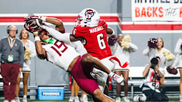 Nov 21, 2025; Raleigh, North Carolina, USA; NC State Wolfpack defensive back Devon Marshall (6) bats the ball away from Florida State Seminoles wide receiver Micahi Danzy (19) during the first half of the game at Carter-Finley Stadium. Mandatory Credit: Jaylynn Nash-Imagn Images