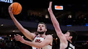 Illinois center Tomislav Ivisic (13) attempts to score as Xavier forward Zach Freemantle goes for a block during the first half of their first round NCAA men’ s basketball tournament game on Friday March 21, 2025 at Fiserv Forum in Milwaukee, Wis.