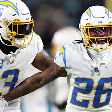 Jan 14, 2023; Jacksonville, Florida, USA; Los Angeles Chargers cornerback Asante Samuel Jr. (26) celebrates with safety Derwin James Jr. (3) after an interception during the second quarter of a wild card game against the Jacksonville Jaguars at TIAA Bank Field. Mandatory Credit: Nathan Ray Seebeck-Imagn Images