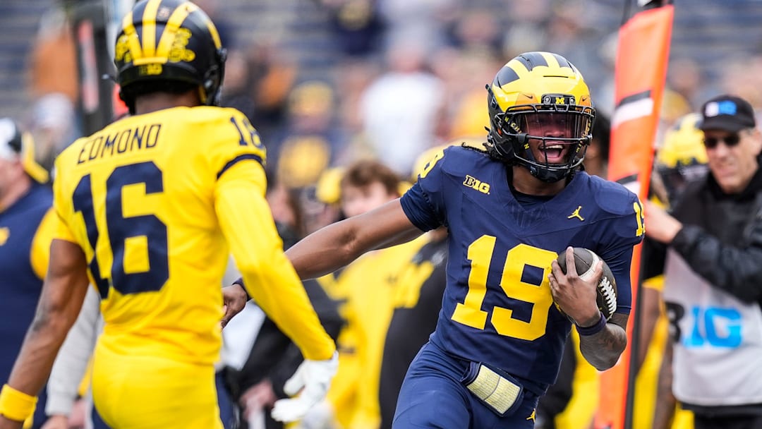 Team Blue quarterback Bryce Underwood (19) runs against Team Maize defensive back Jo'Ziah Edmond (16) during the second half of the spring game at Michigan Stadium in Ann Arbor on Saturday, April 19, 2025.