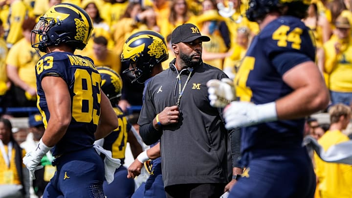 Michigan head coach Sherrone Moore, center, watches warm up before the Texas game at Michigan Stadium in Ann Arbor on Saturday, September 7, 2024.