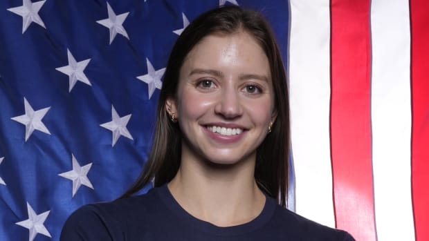 U.S. swimmer Kate Douglass poses for a photo in front of an American flag.