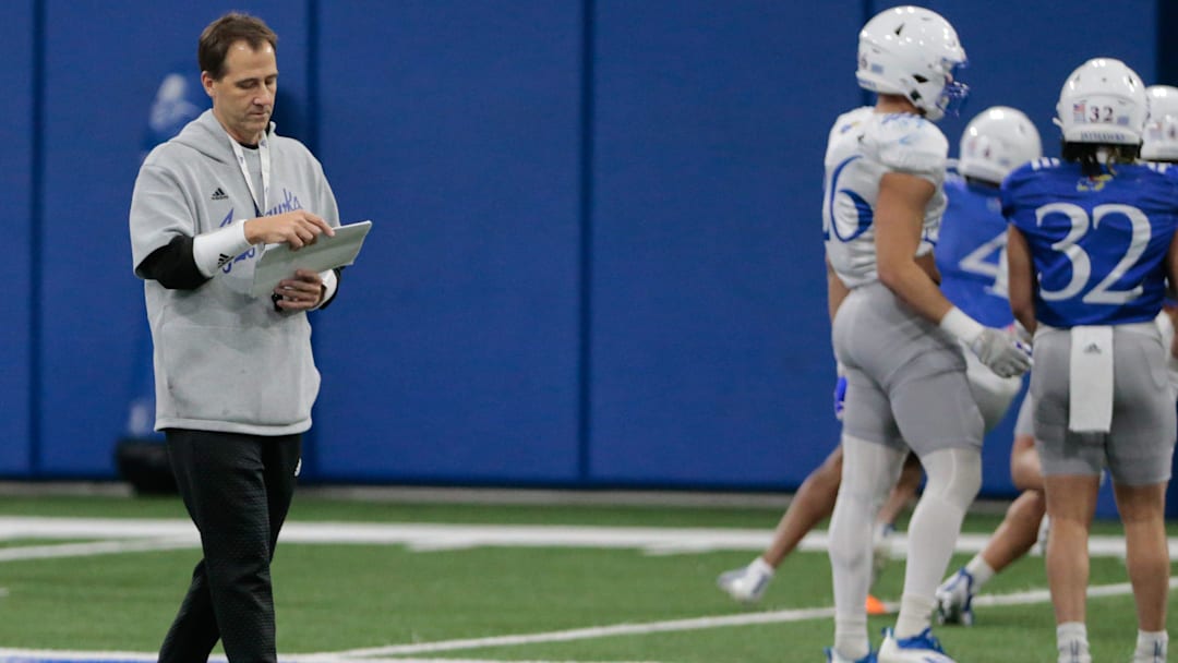 Kansas quarterback coach Jim Zebrowski reviews notes during Tuesday morning's practice within the Indoor Football Facility.