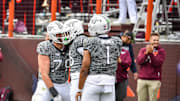 Nov 22, 2025; Blacksburg, Va.; Virginia Tech offensive lineman Johnny Garrett (79) and quarterback Kyron Drones (1) celebrate with running back Jeffrey Overton (16).