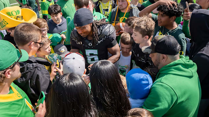 Combat Ducks running back Noah Whittington signs autographs amid a mob of fans as the Fighting Ducks face off against Mighty Oregon in the Oregon Ducks spring game on April 26, 2025, at Autzen Stadium in Eugene.