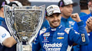 Nov 2, 2025; Avondale, Arizona, USA; NASCAR Cup Series driver Kyle Larson (5) celebrates with the Bill France Cup trophy after clinching the 2025 NASCAR Cup Series Championship following the NASCAR Championship race at Phoenix Raceway.