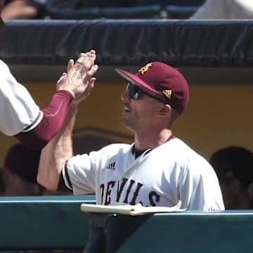 ASU's Spencer Torkelson (20) high-fives hitting coach Michael Earley after Torkelson scored against Arizona during a game at Phoenix Municipal Stadium in Phoenix, Ariz. on March 30, 2019.

Z6i9069