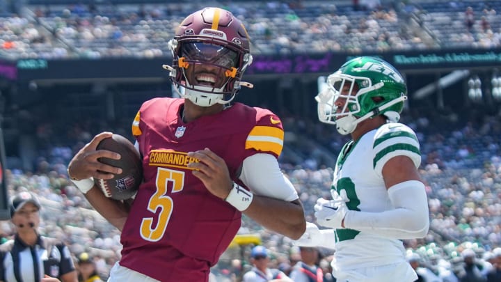 Aug 10, 2024; East Rutherford, New Jersey, USA; Washington Commanders quarterback Jayden Daniels (5) rushes for a touchdown during the first quarter against the New York Jets at MetLife Stadium. Mandatory Credit: Lucas Boland-USA TODAY Sports