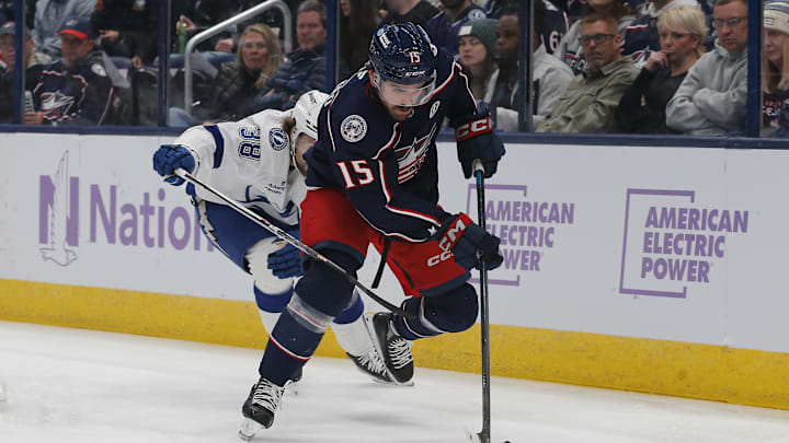Nov 21, 2024; Columbus, Ohio, USA; Columbus Blue Jackets defenseman Dante Fabbro (15) picks up a loose puck as Tampa Bay Lightning left wing Brandon Hagel (38) trails the play during the first period at Nationwide Arena. Mandatory Credit: Russell LaBounty-Imagn Images