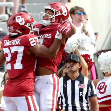 Oklahoma's Nic Anderson (4) celebrates his touchdown with Gavin Sawchuk (27) lin the first half of the college football game between the University of Oklahoma Sooners and the University of Central Florida Knights at Gaylord Family Oklahoma-Memorial Stadium in Norman, Okla., Saturday, Oct., 21, 2023.