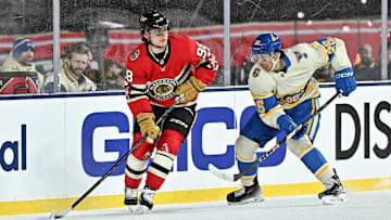 Dec 31, 2024; Chicago, Illinois, USA; Chicago Blackhawks center Connor Bedard (98) skates with the puck against St. Louis Blues center Jordan Kyrou (25) during the third period in the Winter Classic at Wrigley Field. Mandatory Credit: Daniel Bartel-Imagn Images