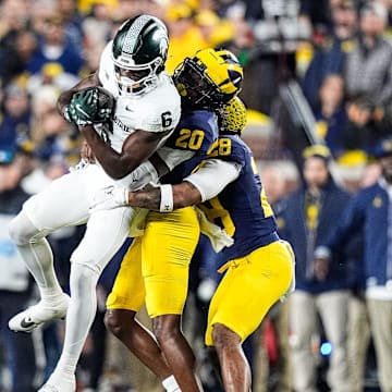 Michigan State wide receiver Nick Marsh (6) makes a catch against Michigan defensive backs Jyaire Hill (20) and Quinten Johnson (28) 