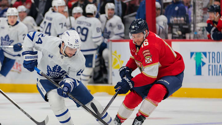 Apr 8, 2025; Sunrise, Florida, USA; Toronto Maple Leafs left wing Scott Laughton (24) and Florida Panthers center Aleksander Barkov (16) battle for the puck during the third period at Amerant Bank Arena. Mandatory Credit: Sam Navarro-Imagn Images