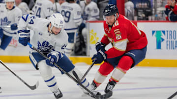 Apr 8, 2025; Sunrise, Florida, USA; Toronto Maple Leafs left wing Scott Laughton (24) and Florida Panthers center Aleksander Barkov (16) battle for the puck during the third period at Amerant Bank Arena. Mandatory Credit: Sam Navarro-Imagn Images