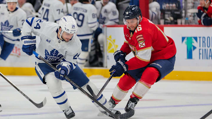 Apr 8, 2025; Sunrise, Florida, USA; Toronto Maple Leafs left wing Scott Laughton (24) and Florida Panthers center Aleksander Barkov (16) battle for the puck during the third period at Amerant Bank Arena. Mandatory Credit: Sam Navarro-Imagn Images
