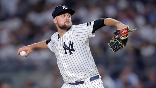 New York Yankees relief pitcher JT Brubaker pitches while wearing a white pinstriped uniform and black hat