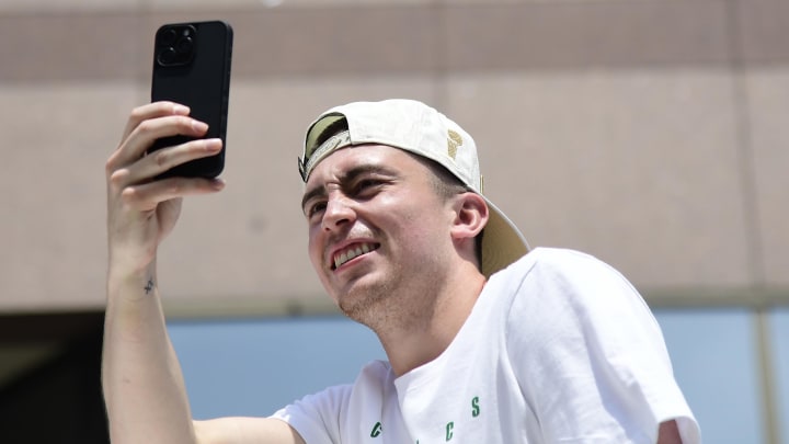 Jun 21, 2024; Boston, MA, USA;  Boston Celtics player Payton Pritchard holds up his phone during the Boston Celtics championship parade. Mandatory Credit: Bob DeChiara-USA TODAY Sports