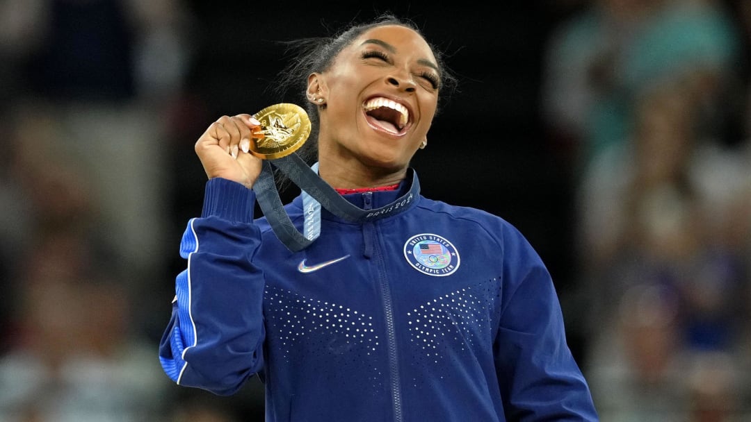 Simone Biles celebrates her gold medal during the medal ceremony for the vault on the first day of gymnastics event finals during the Paris 2024 Olympic Summer Games at Bercy Arena.