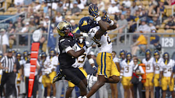 Oct 18, 2025; Orlando, Florida, USA;  West Virginia Mountaineers cornerback Jason Chambers (23) makes an interception on a pass intended for Central Florida Knights wide receiver Waden Charles (19) in the second half at Acrisure Bounce House. Mandatory Credit: Russell Lansford-Imagn Images